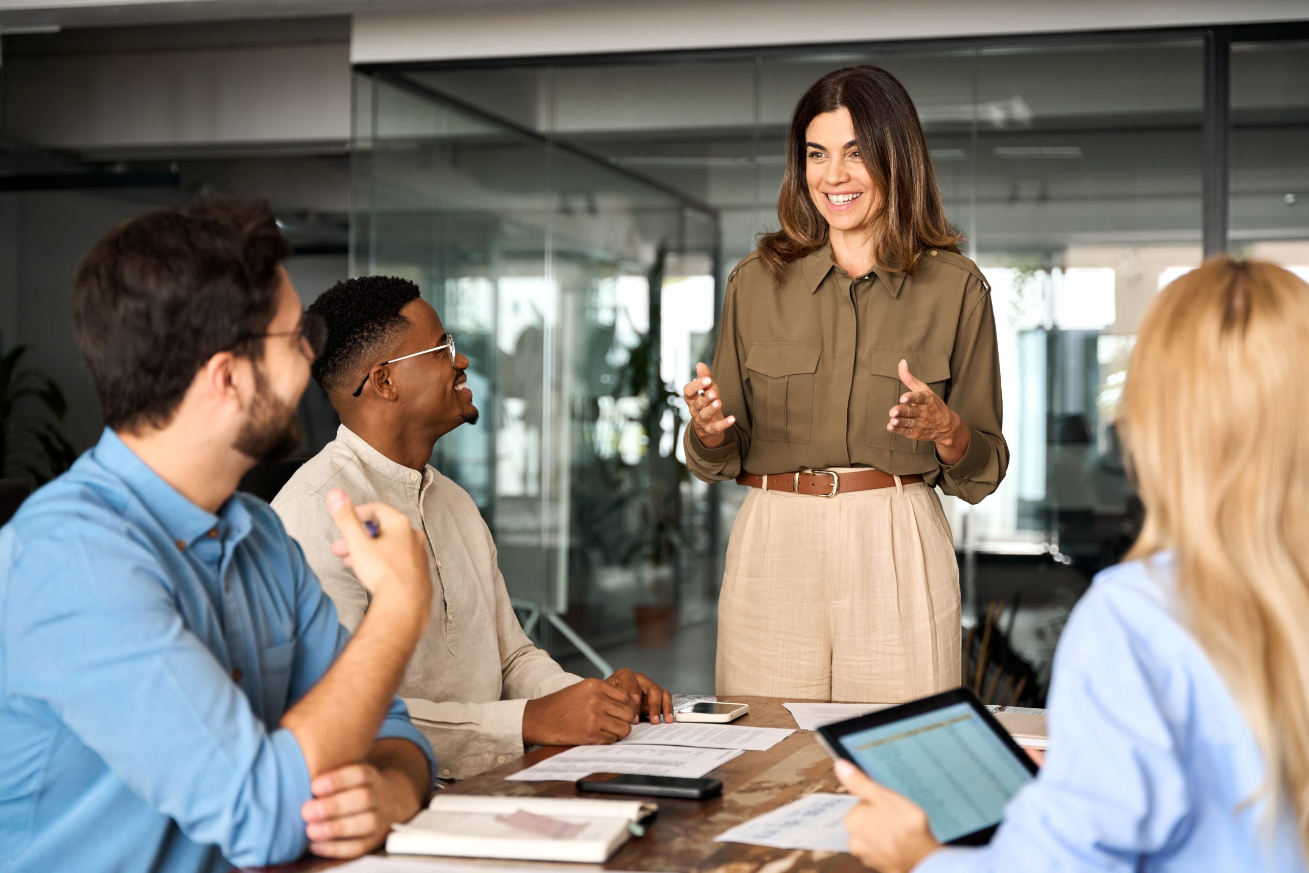 Femme d'affaires heureuse de travailler avec son équipe lors d'une réunion.