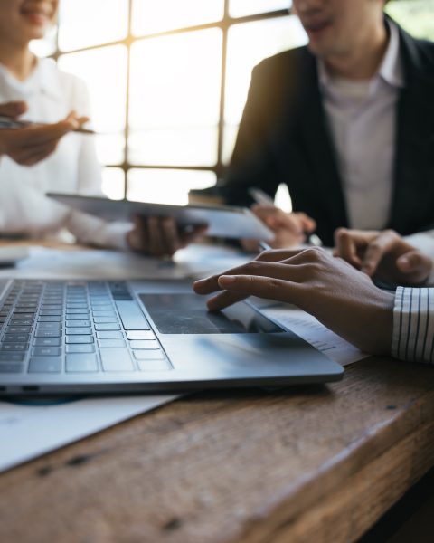 Une équipe de consultants en investissement analyse le rapport financier annuel d'une entreprise.