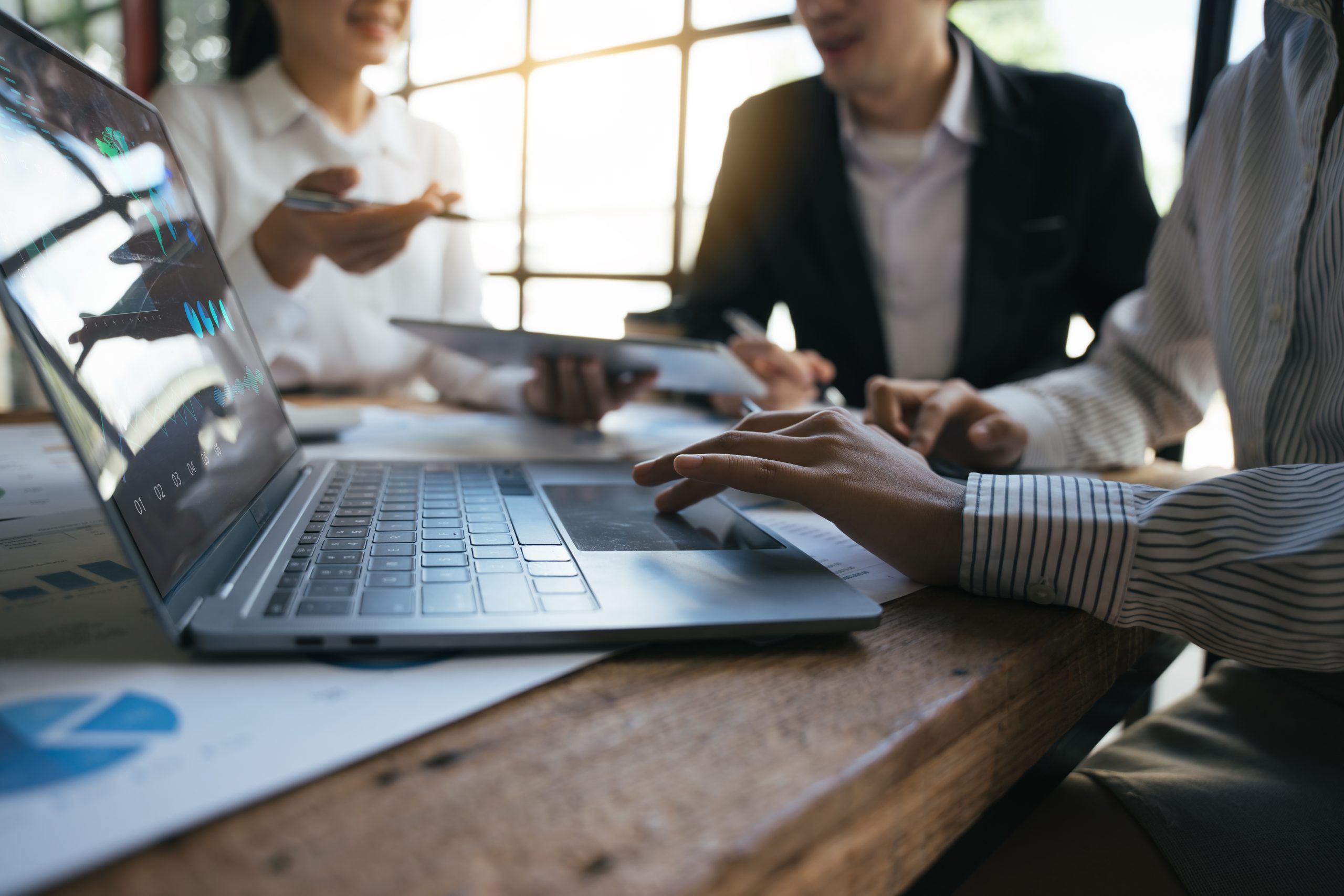 Une équipe de consultants en investissement analyse le rapport financier annuel d'une entreprise.