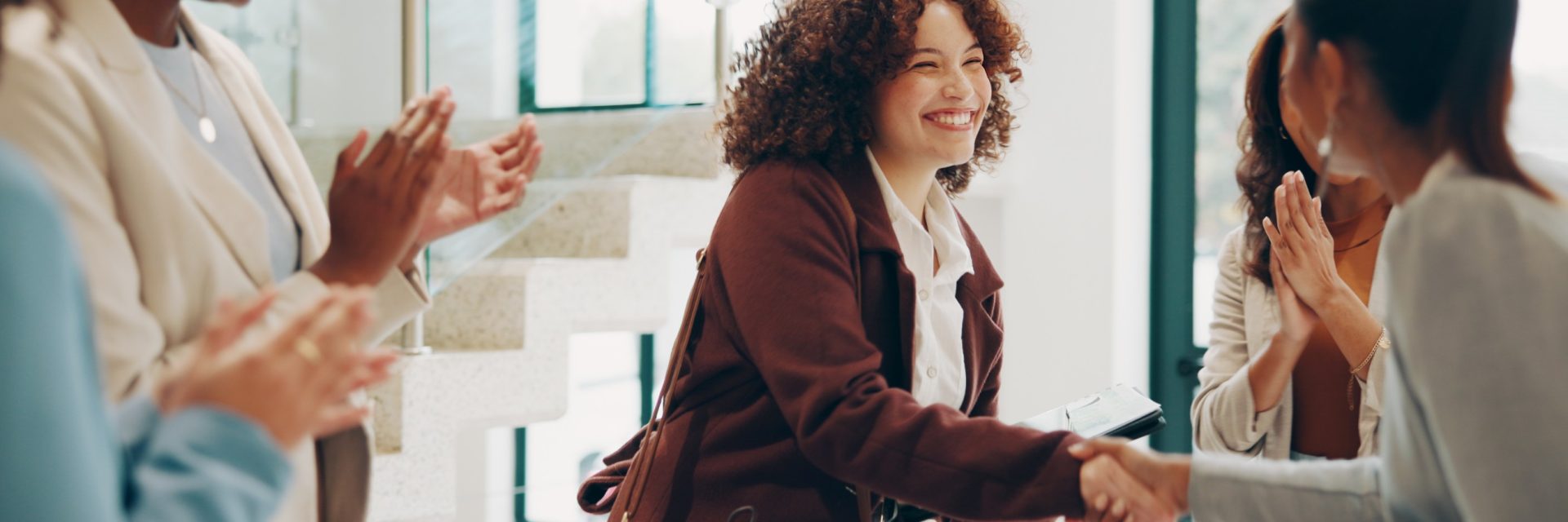 Des employés, femmes et hommes, heureux au bureau, se serrent la main pour le recrutement, l'accueil et la conclusion d'un accord.
