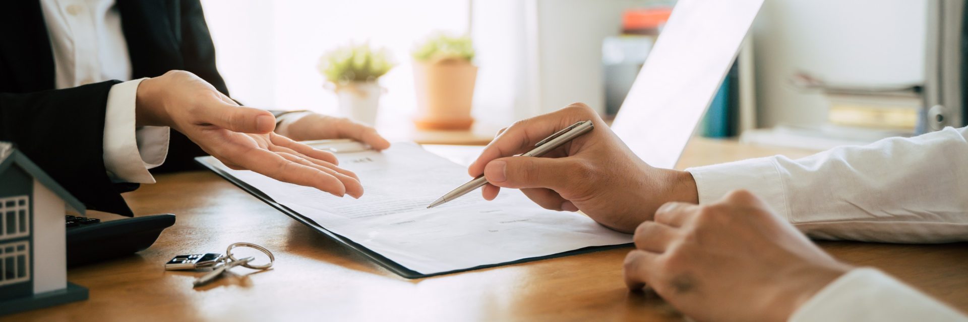 Mains d'un propriétaire et d'un locataire signant un contrat